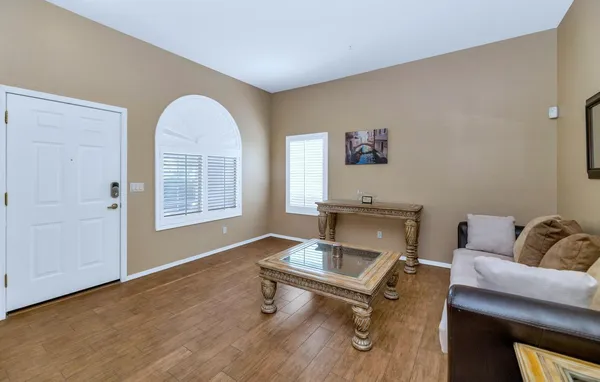 a view of a livingroom with wooden floor and a chandelier