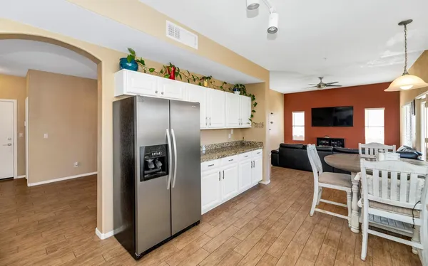 a kitchen with stainless steel appliances granite countertop wooden floor cabinets dining table and chairs