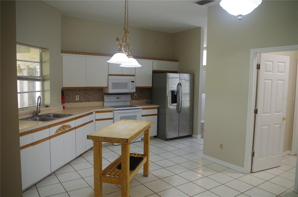 4207 Elba Place Valrico, FL 33596 - Photo 11 of 24 a kitchen with granite countertop white cabinets and refrigerator