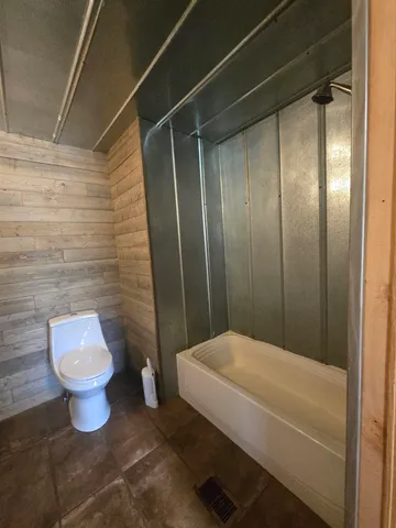 a bathroom with a toilet and a shower
