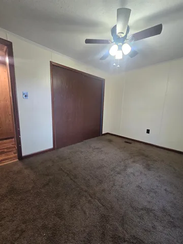a view of an empty room with a chandelier fan