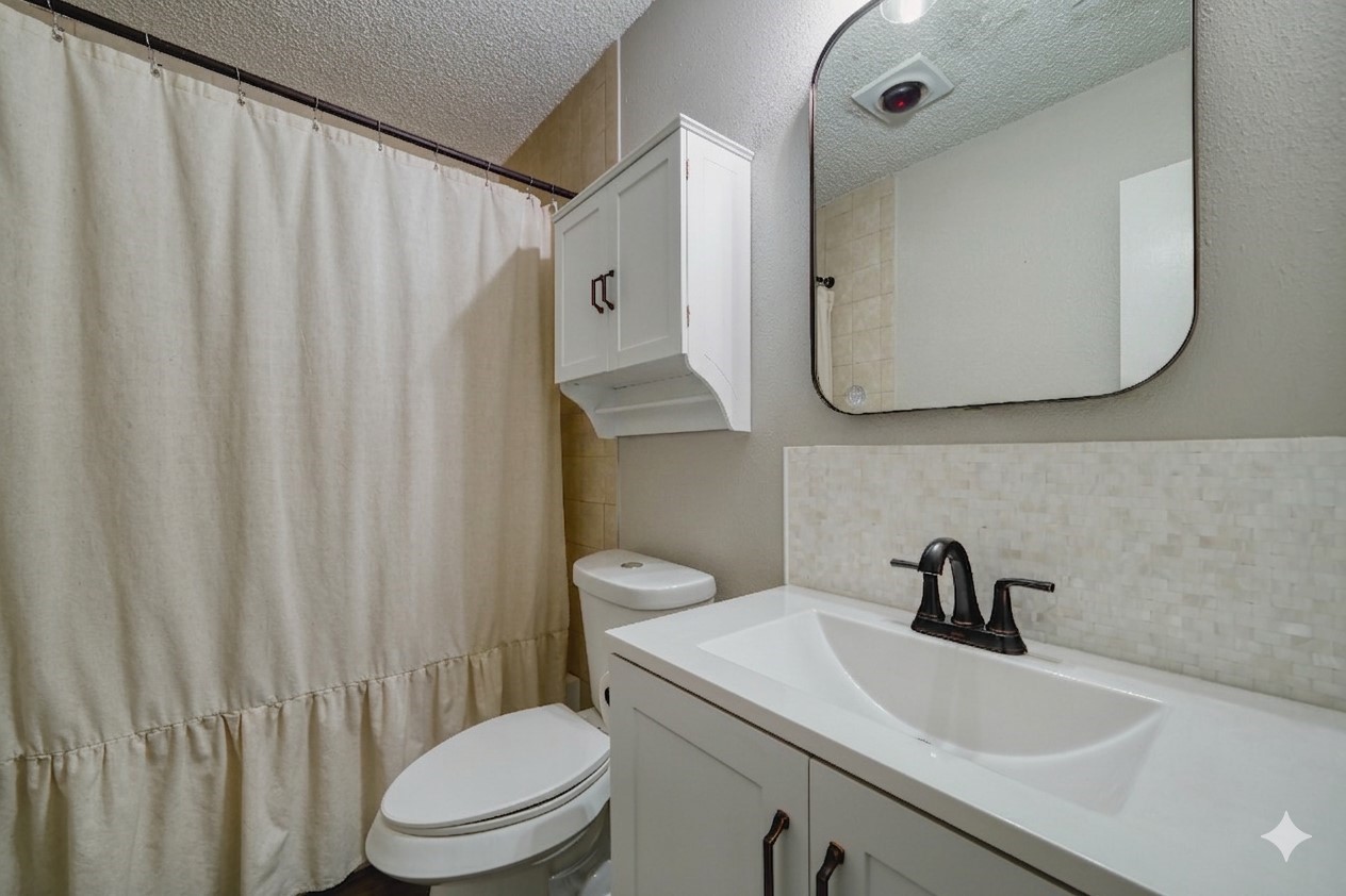 5402 Sherrylee Lane Spring, TX 77373 - Photo 13 of 21 This modern and impeccably clean guest bath features a seamless design with a crisp white vanity and a stunning mosaic tile backsplash. Your guests will love the welcoming aesthetic and the sleek, high-contrast matte black fixtures that elevate the space.