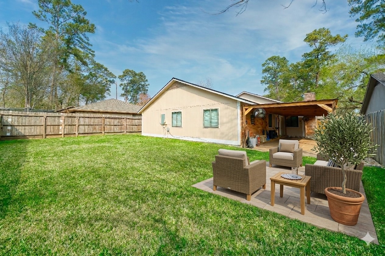 5402 Sherrylee Lane Spring, TX 77373 - Photo 4 of 21 This virtually staged backyard features a lush green lawn and private wooden fencing. The tiled patio is enhanced with a large covered area providing the perfect shaded retreat for outdoor living.