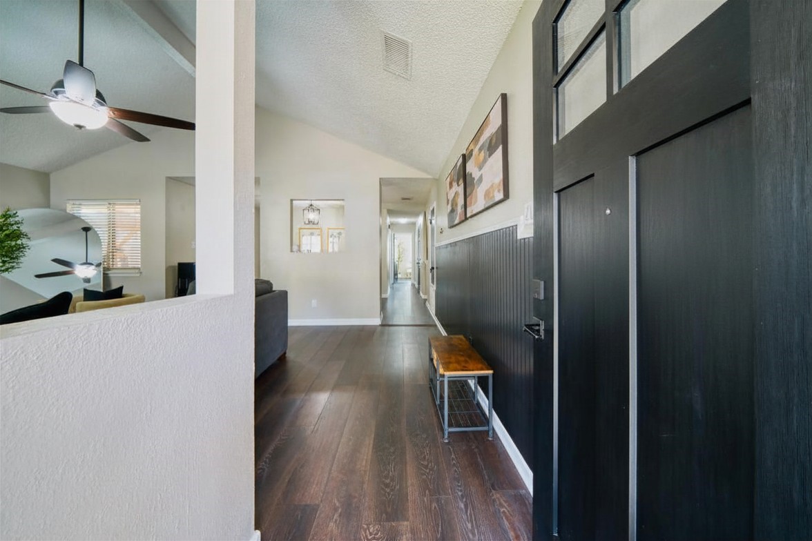5402 Sherrylee Lane Spring, TX 77373 - Photo 6 of 21 This entryway features a warm wood floor leading to a bright, open living area with high ceilings and modern ceiling fans.