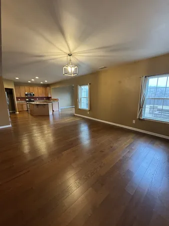 an empty room with wooden floor and fireplace