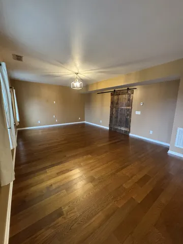 an empty room with wooden floor and door