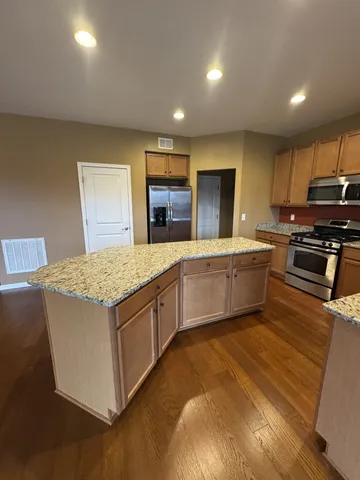 a kitchen with kitchen island a sink appliances and cabinets