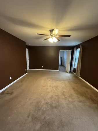 a view of an empty room with a chandelier fan