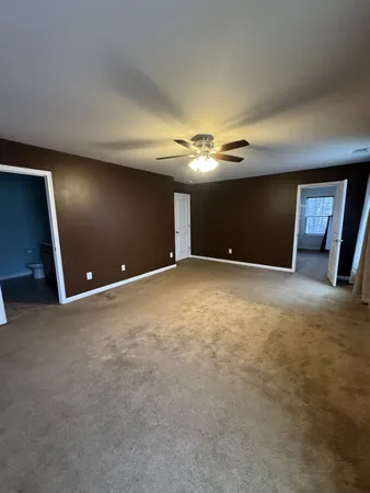 a view of an empty room with a chandelier fan