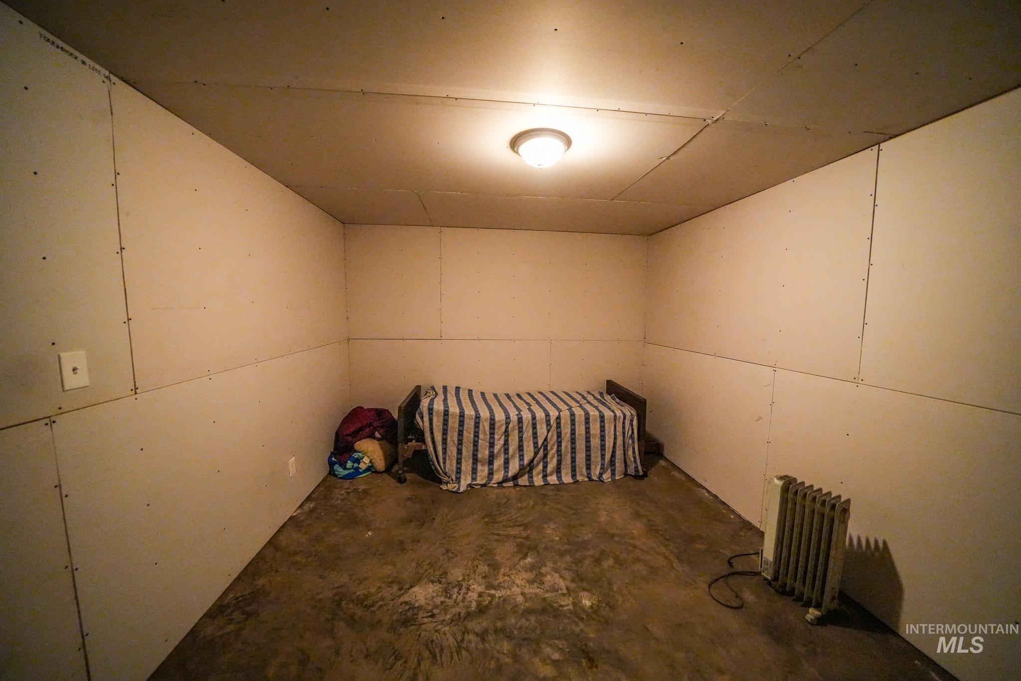10 Main Street South Pierce, ID 83546 - Photo 23 of 27 Unfurnished bedroom featuring concrete flooring and radiator heating unit