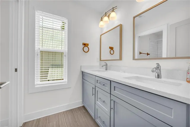 a bathroom with double vanity sink a window and a mirror