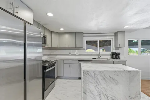 a kitchen with stainless steel appliances granite countertop a sink stove and refrigerator