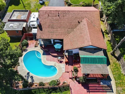 an aerial view of a house with a yard and trees