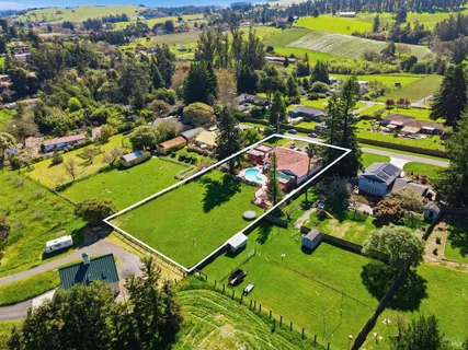 an aerial view of a residential houses with outdoor space and street view