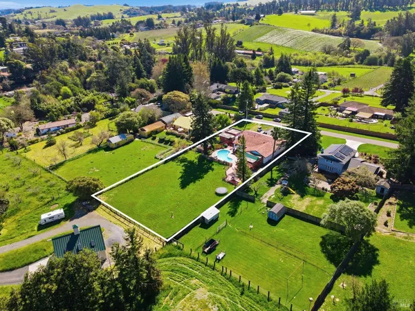 an aerial view of a residential houses with outdoor space and street view