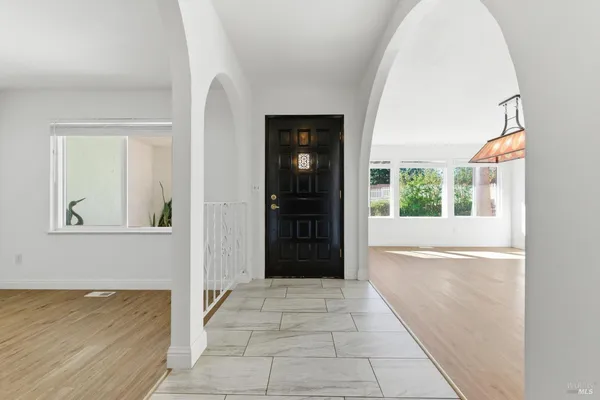 a view of a hallway with wooden floor and a living room