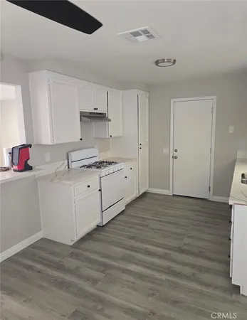 a kitchen with a sink cabinets and wooden floor