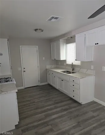 a kitchen with a sink cabinets stainless steel appliances and a window