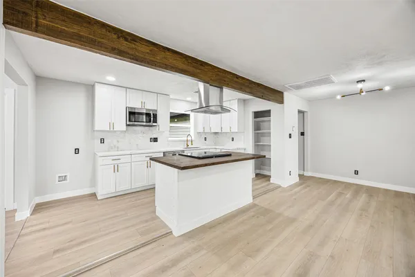 a kitchen with granite countertop a sink cabinets stainless steel appliances and a counter top space