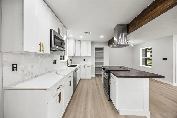 a kitchen with stainless steel appliances granite countertop a stove and a refrigerator