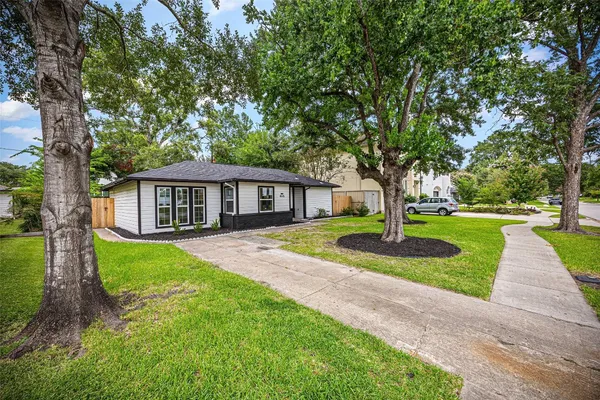 a front view of a house with a yard and trees