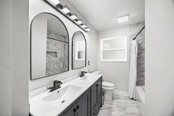a bathroom with a toilet a sink and mirror