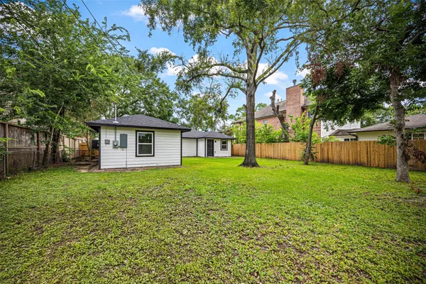 a view of a house with backyard and a tree