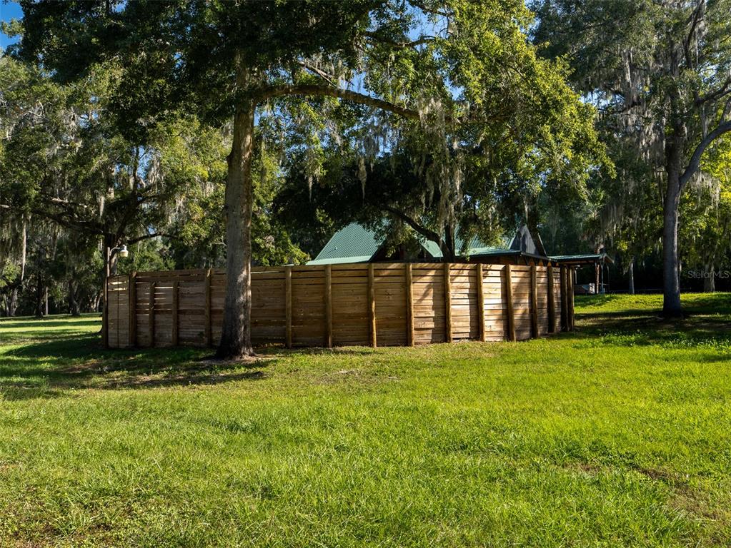 12100 Northwest 110th Avenue Reddick, FL 32686 - Photo 29 of 38 a view of a backyard with large trees and wooden fence