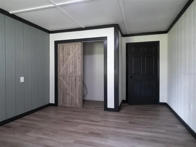 an empty room with wooden floor and closet