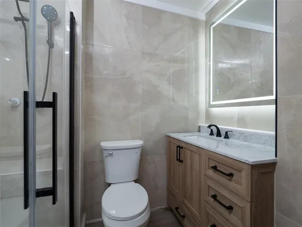 a bathroom with a granite countertop sink toilet and shower