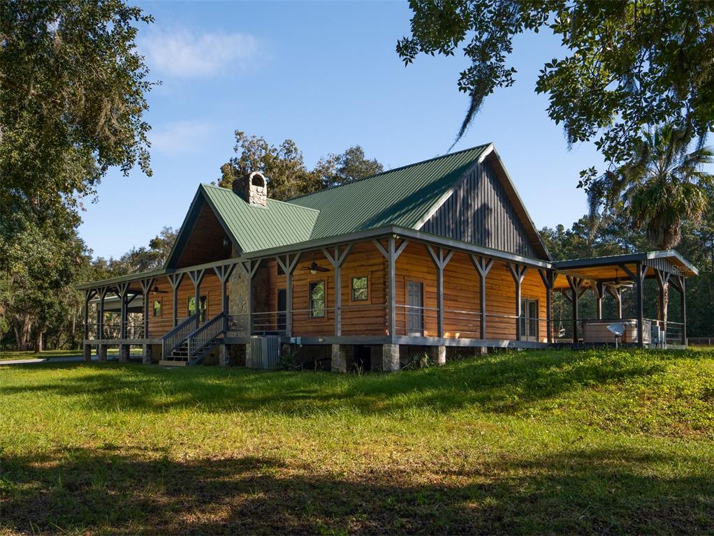 12100 Northwest 110th Avenue Reddick, FL 32686 - Photo 4 of 38 a front view of a house with a yard table and chairs