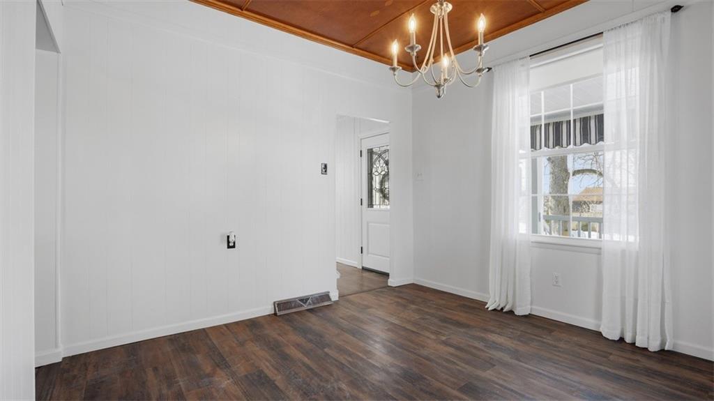 1105 Linden Street Monaca, PA 15061 - Photo 25 of 45 an empty room with wooden floor chandelier and windows