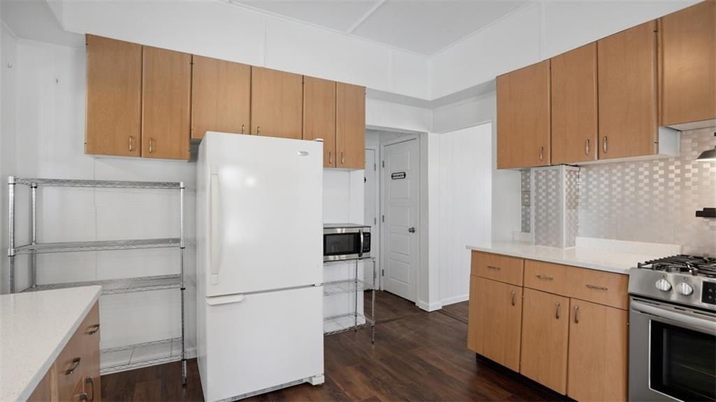 1105 Linden Street Monaca, PA 15061 - Photo 30 of 45 a white refrigerator freezer sitting inside of a kitchen with stainless steel appliances wooden floor
