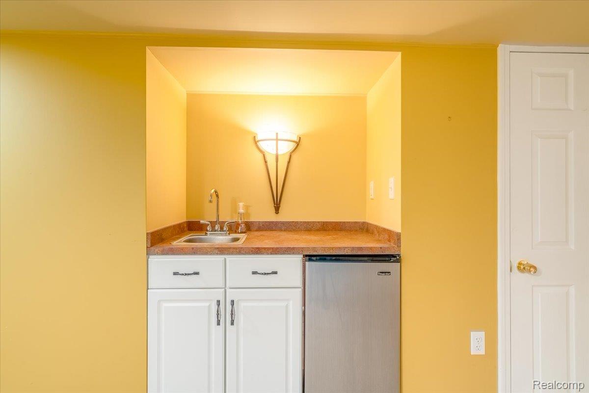 49105 Hawksburry Road Canton, MI 48188 - Photo 35 of 51 Built-in wet bar featuring a stainless-steel sink, ample countertop space, and under-counter refrigeration