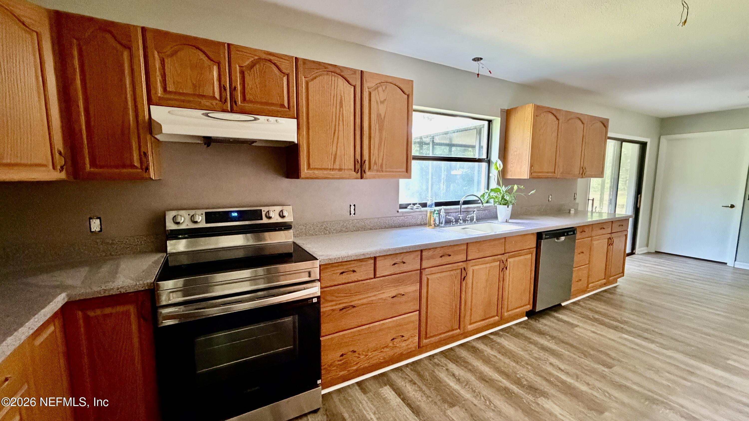 850 Cousintown Road Interlachen, FL 32148 - Photo 8 of 27 a kitchen with stainless steel appliances granite countertop a stove a sink and a microwave