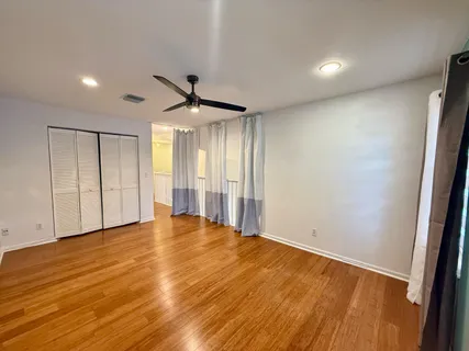 an empty room with wooden floor and windows
