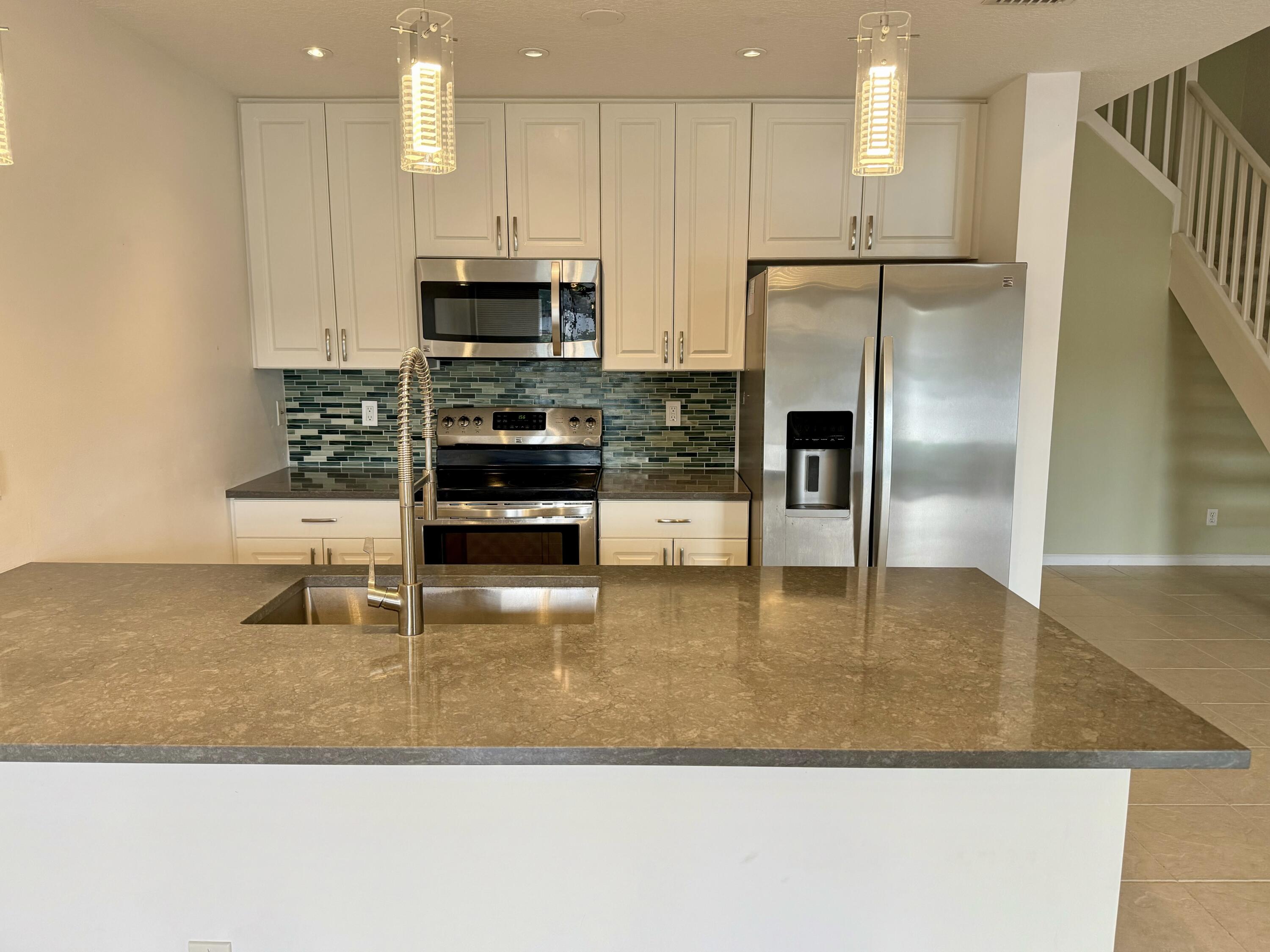 12813 Woodmill Drive Palm Beach Gardens, FL 33418 - Photo 16 of 30 a kitchen with stainless steel appliances granite countertop a refrigerator a stove a microwave and a sink