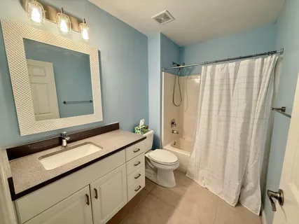 a bathroom with a double vanity sink toilet mirror and shower
