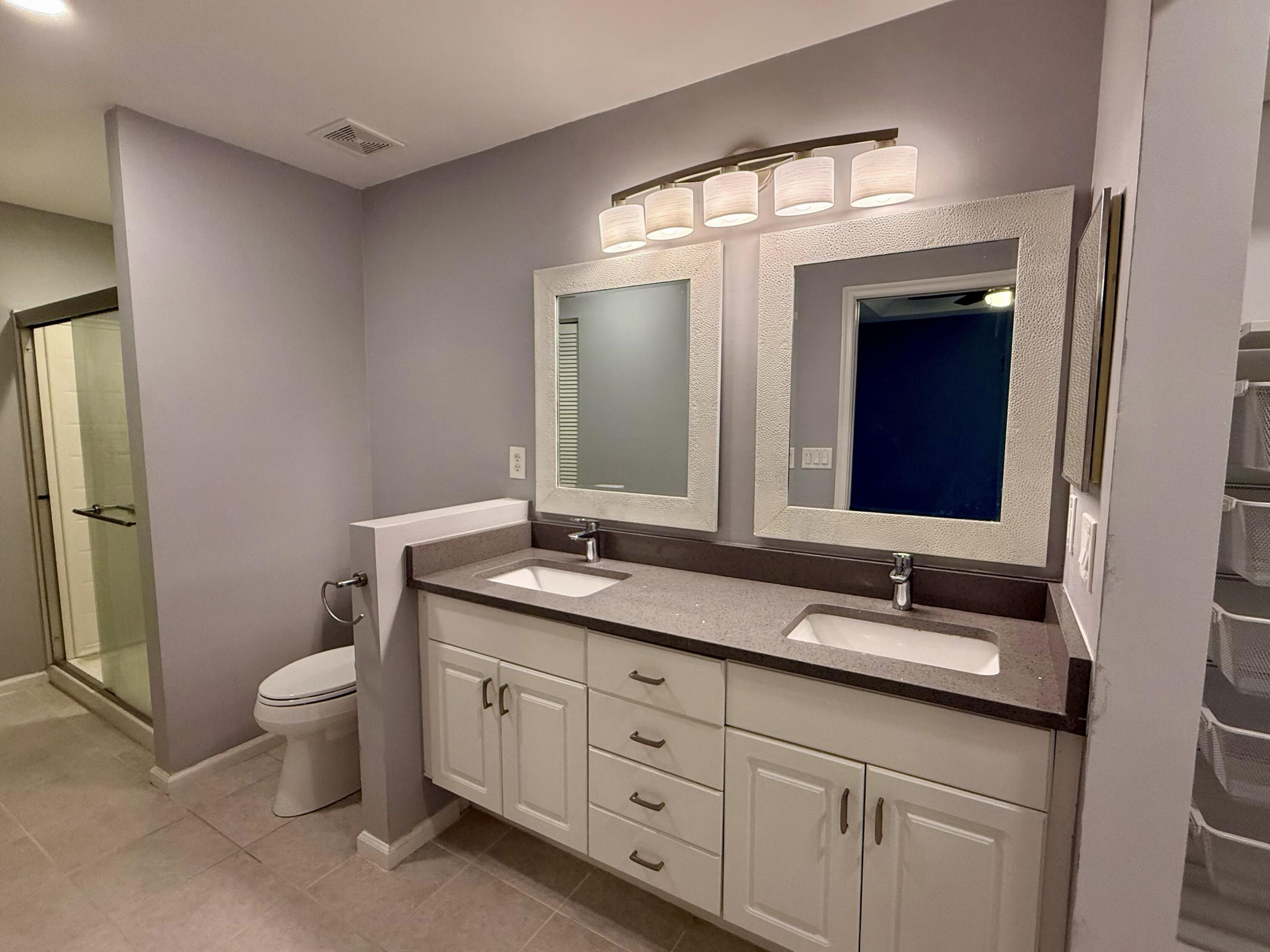 12813 Woodmill Drive Palm Beach Gardens, FL 33418 - Photo 29 of 30 a bathroom with a double vanity sink and a mirror