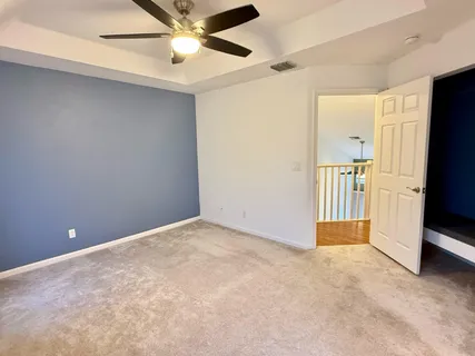an empty room with closet and a ceiling fan