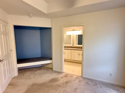 an empty room with cabinet and mirrors