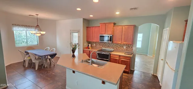 a kitchen with stainless steel appliances granite countertop sink microwave and wooden cabinets
