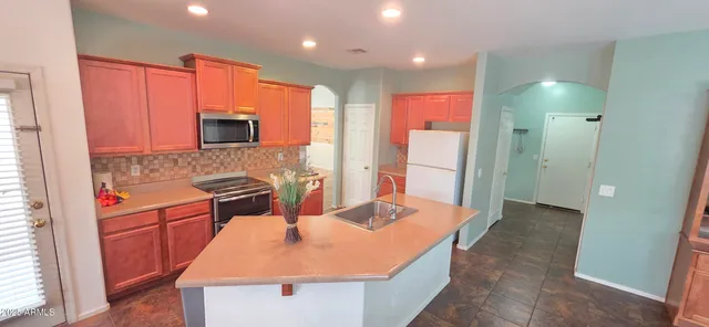 a kitchen with stainless steel appliances granite countertop a sink stove and refrigerator