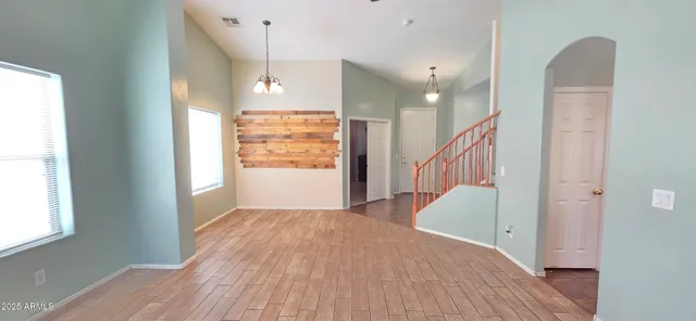 a view of a hallway with wooden floor and staircase