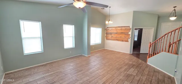 a view of hallway with a window and wooden floor