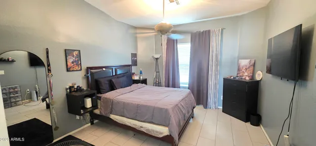 a bedroom with a bed and a flat tv screen