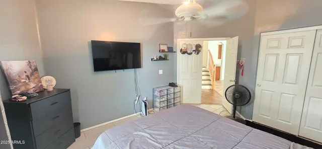 a bedroom with a bed and a flat tv screen on dresser