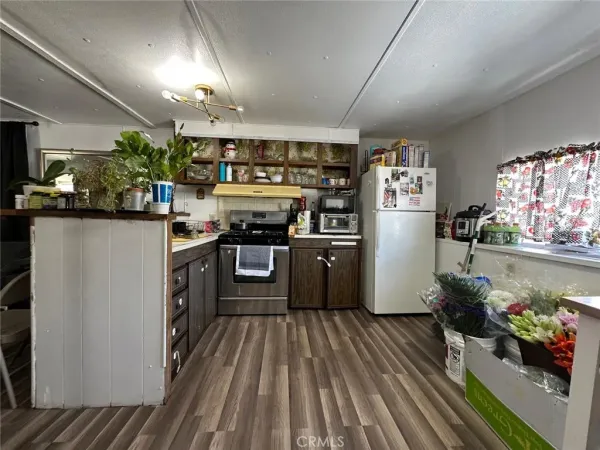 a kitchen with stainless steel appliances granite countertop a refrigerator a stove and a wooden floors