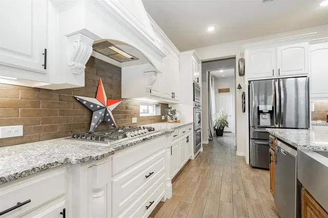 a kitchen with stainless steel appliances granite countertop a sink stove and refrigerator