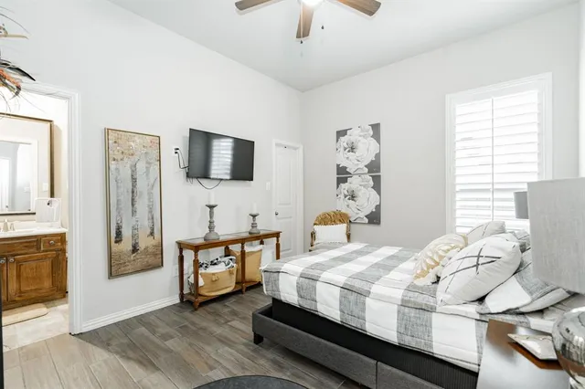 a bedroom with a bed and a flat tv screen on dresser